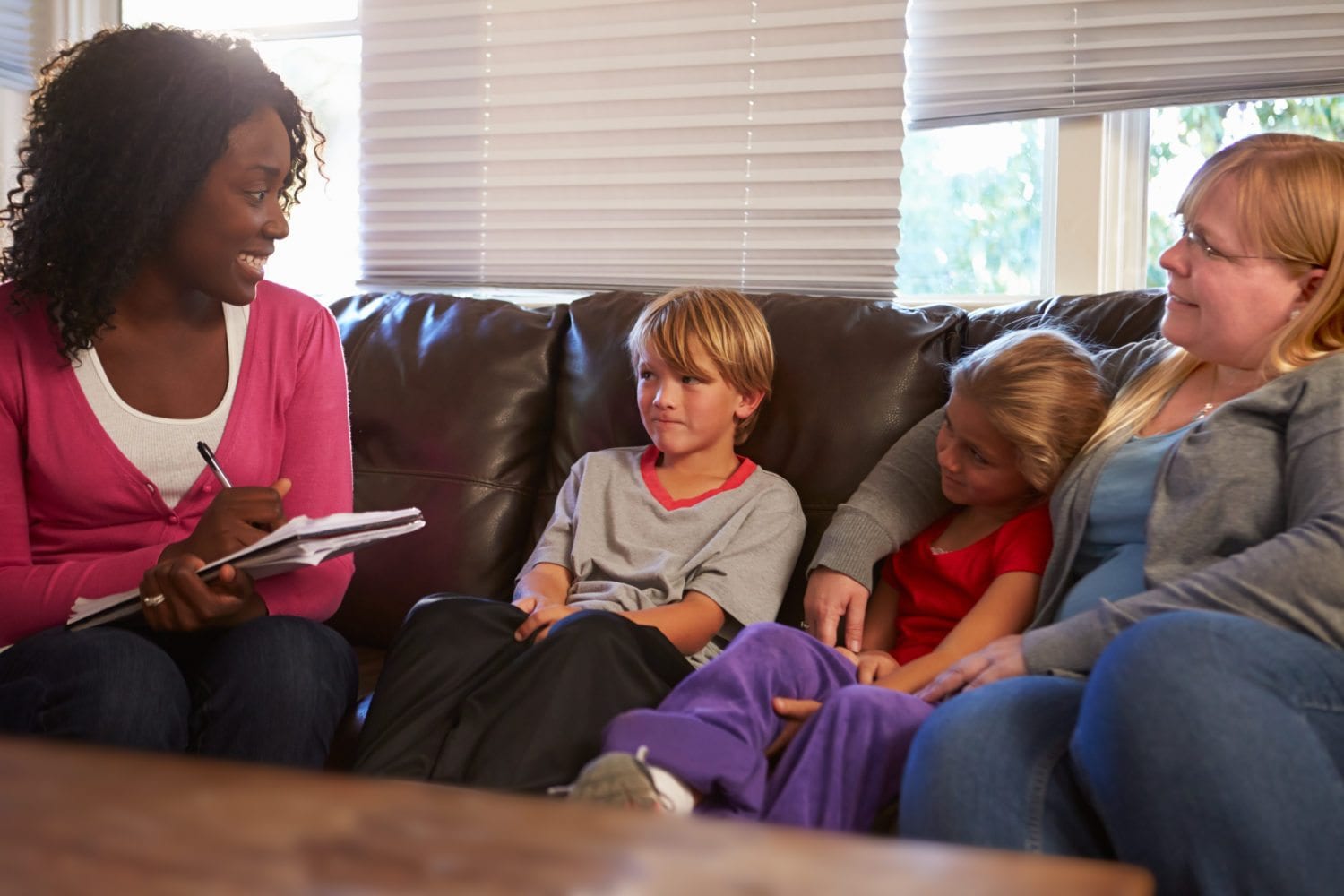 Social Worker Talking To Mother And Children At Home